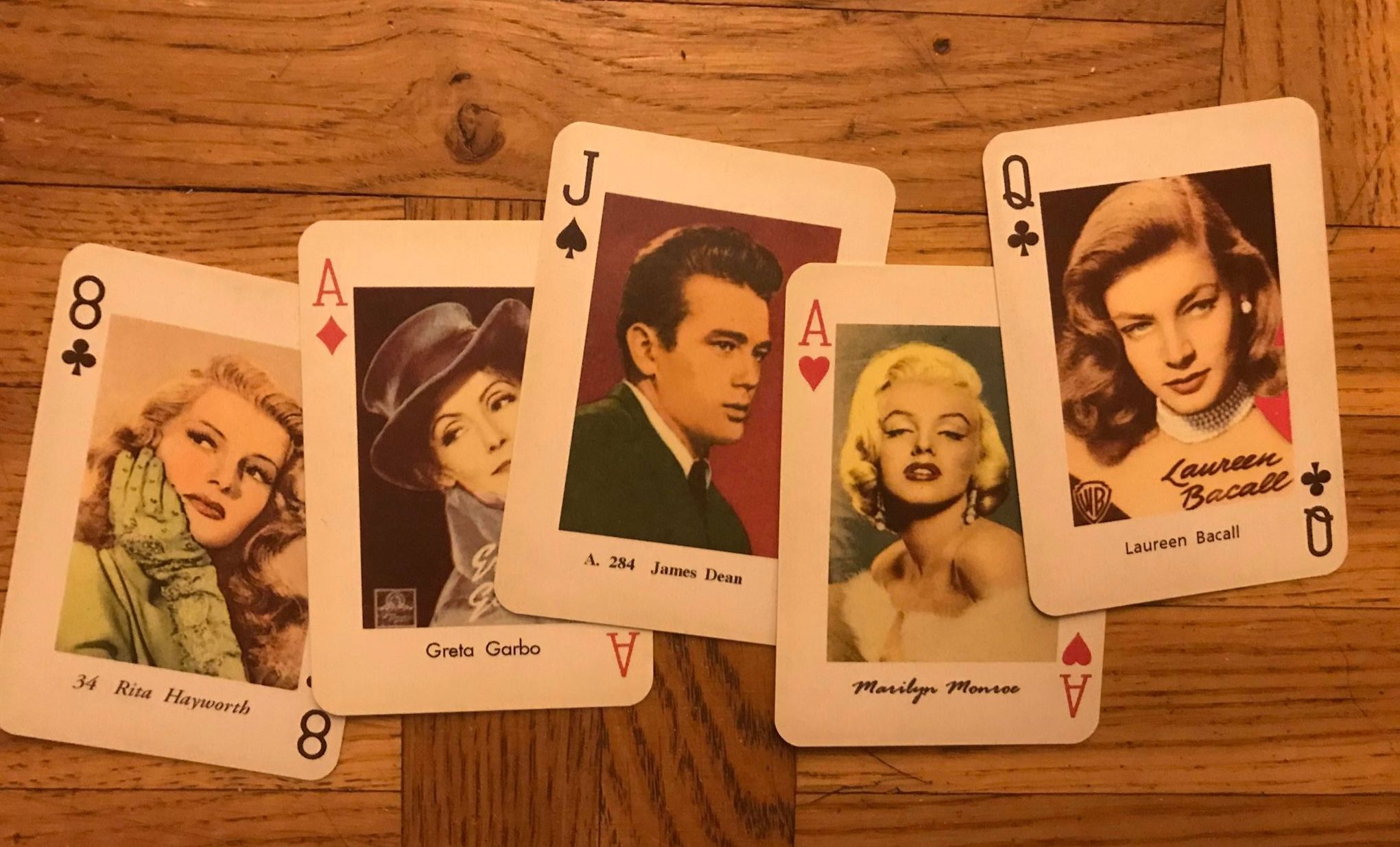 Fem spelkort med bilder på kända skådespelare, bl. a. James Dean och Marilyn Monroe. Denna bild ska symbolisera populärkultur.